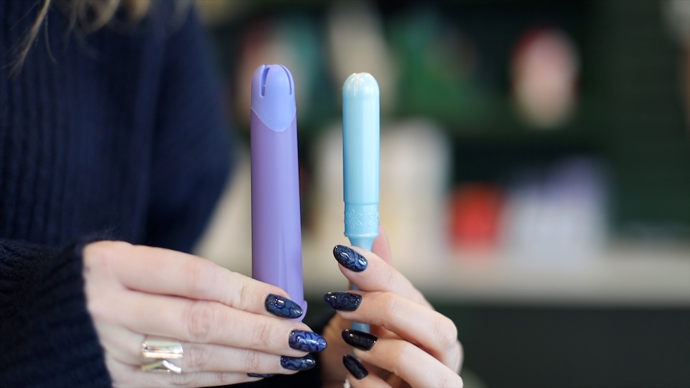 woman showing on the left, a purple fillow disc applicator, on the right, a super tampon applicator